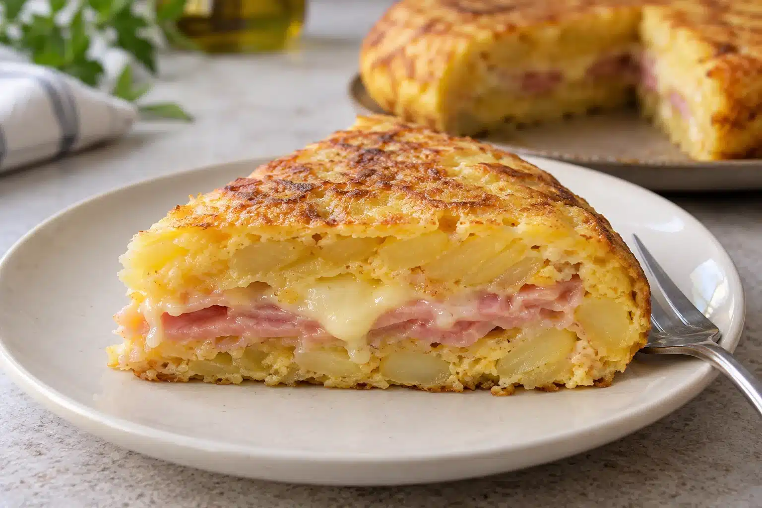 Porción de tortilla rellena con jamón cocido y queso fundido