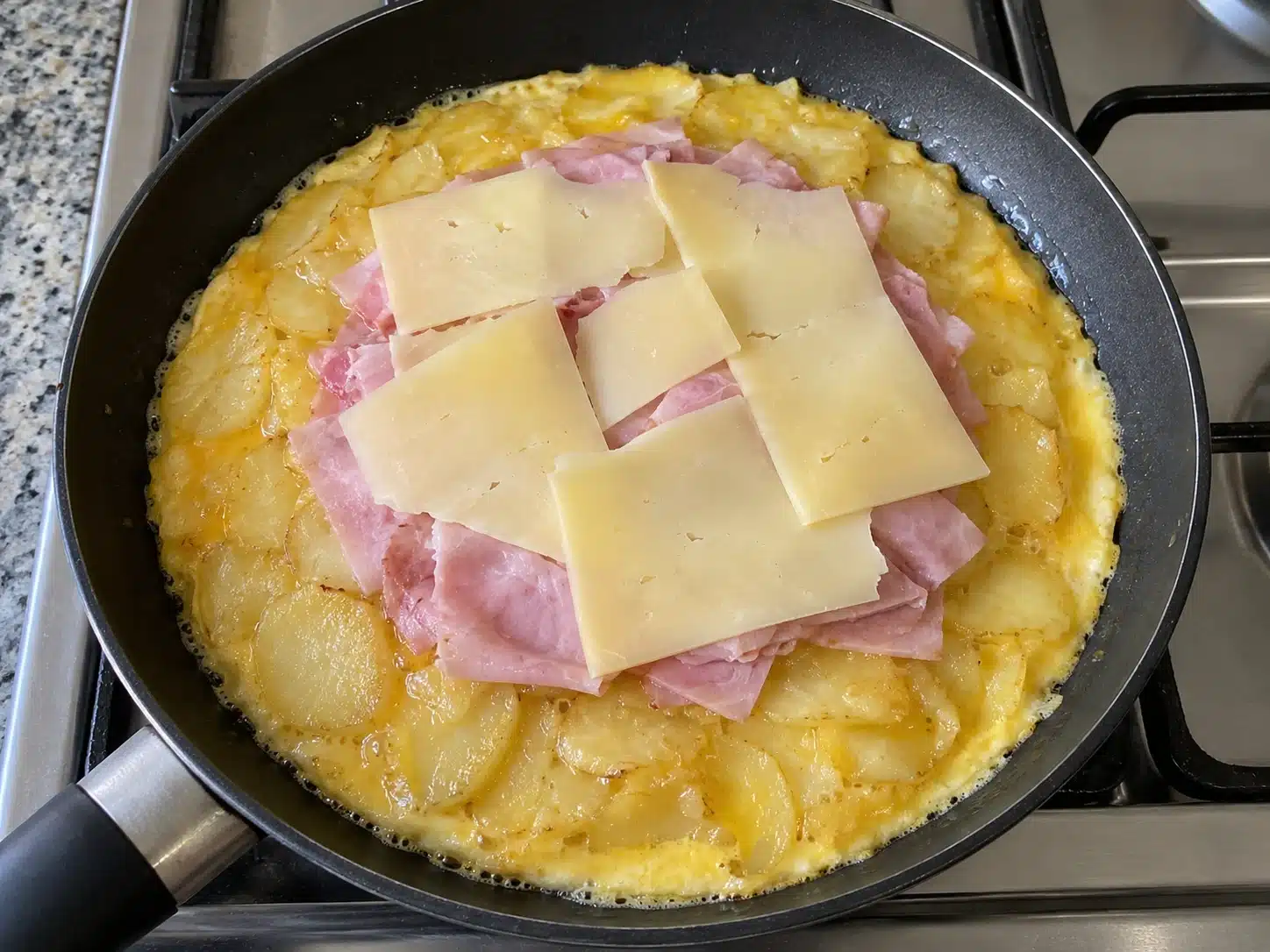 Jamón y queso colocados sobre las patatas dejando libre el borde